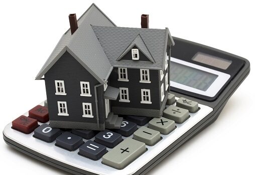 Mortgage Calculator House sitting on calculator isolated on white